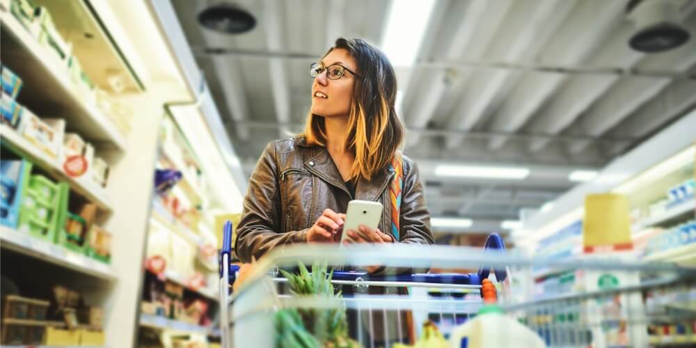 Young woman pushing a cart through the grocery store