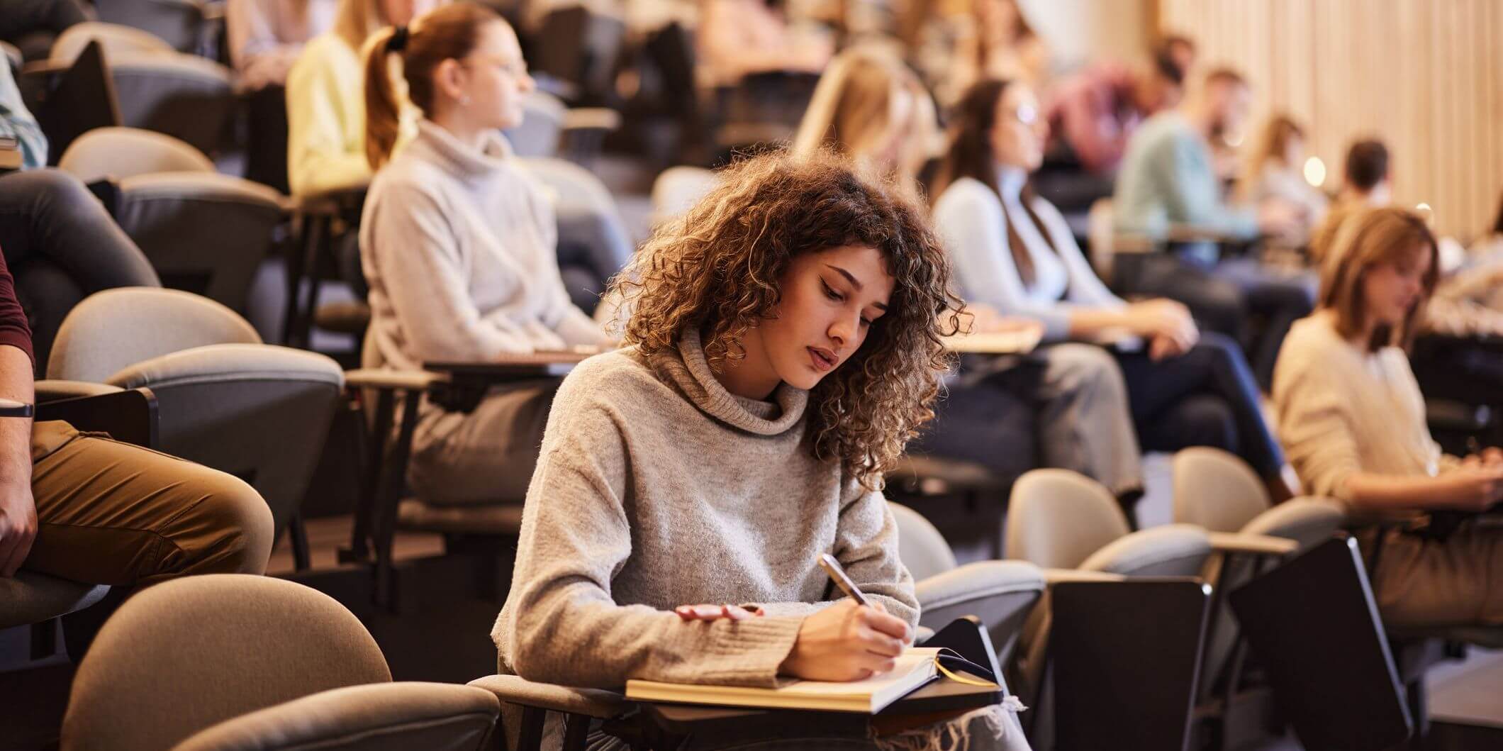 Student taking notes in class.