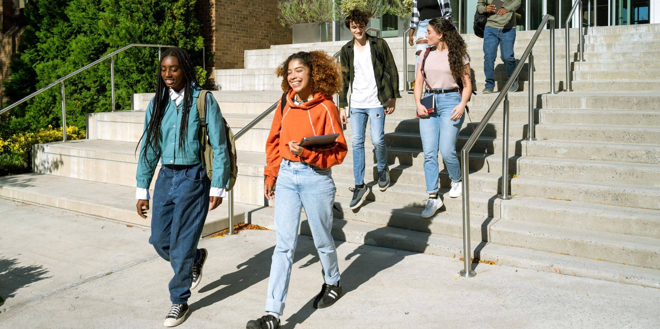 Students walk down steps of academic building