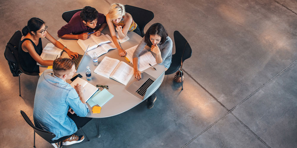Photo from above of students sitting at a table.