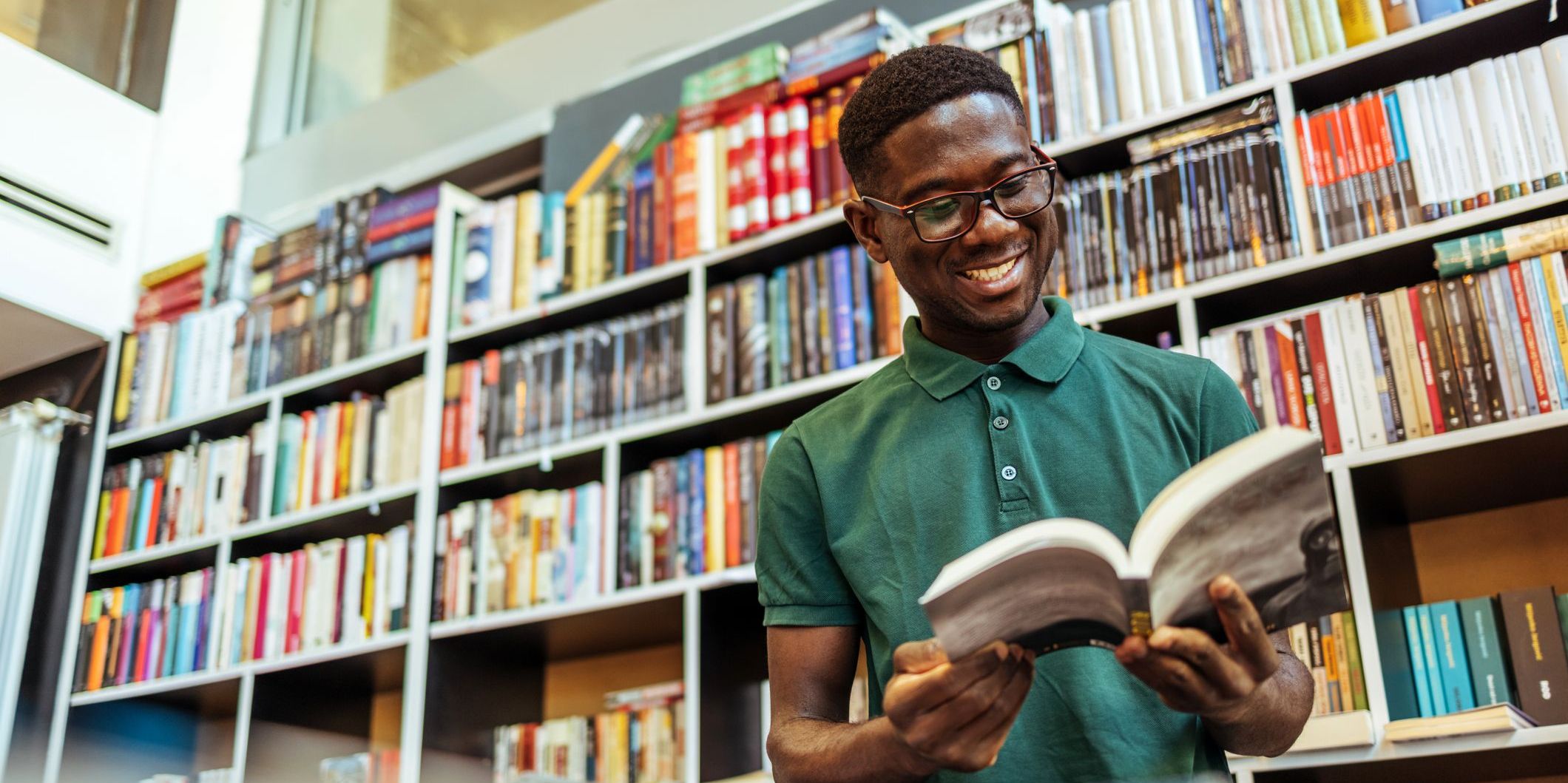 Smiling male student working in a library