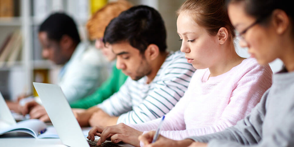 Image of a row of students in a classroom.